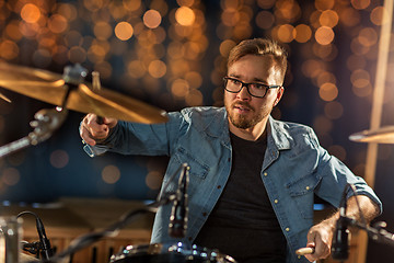 Image showing musician playing drum kit at concert over lights