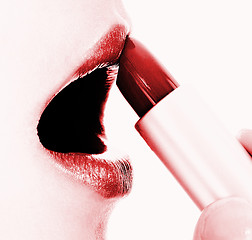 Image showing Applying Red Glossy Lipstick To Her Lips
