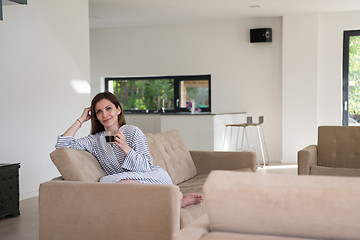 Image showing young woman in a bathrobe enjoying morning coffee