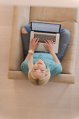 Image showing Young woman using laptop at home top view