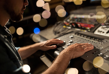 Image showing man using mixing console in music recording studio