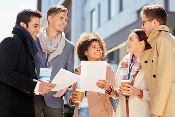 Image showing international business team with papers outdoors