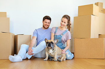 Image showing happy couple with boxes and dog moving to new home