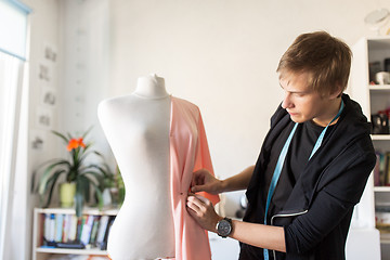 Image showing fashion designer with dummy making dress at studio