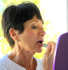 Image showing Female applying makeup.