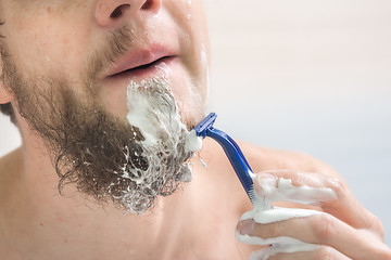 Image showing The guy shaves his beard, close-up