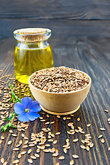 Image showing Flaxen brown seed in bowl with flower and oil on board