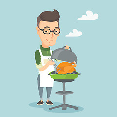 Image showing Man cooking chicken on barbecue grill.