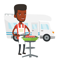 Image showing Man having barbecue in front of camper van.