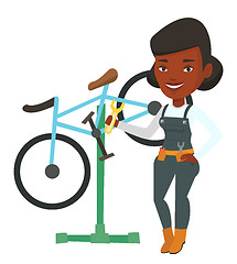 Image showing African bicycle mechanic working in repair shop.