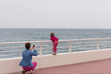 Image showing mother and cute little girl on the promenade by the sea