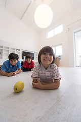 Image showing boys having fun with an apple on the floor