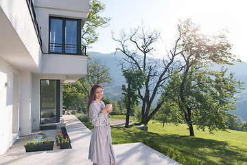 Image showing woman in a bathrobe enjoying morning coffee