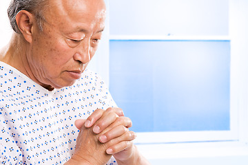 Image showing Praying senior asian in hospital
