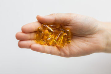 Image showing hand holding cod liver oil capsules