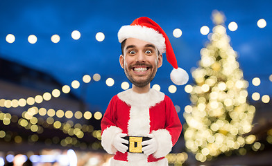 Image showing man in santa claus costume over christmas lights