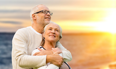 Image showing happy senior couple over sunset background