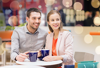 Image showing happy couple with shopping bags drinking coffee