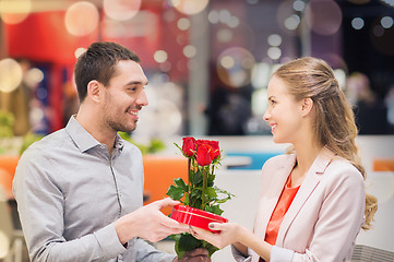 Image showing happy couple with present and flowers in mall