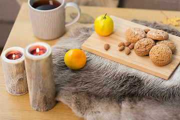 Image showing cookies, lemon tea and candles on table at home