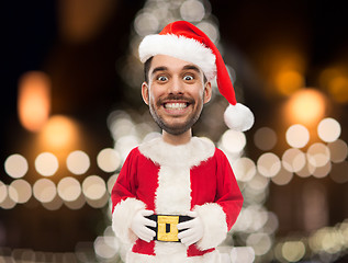 Image showing man in santa claus costume over christmas lights