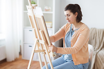 Image showing artist with easel drawing picture at art studio