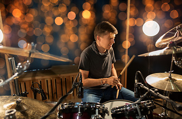 Image showing musician playing drum kit at concert over lights