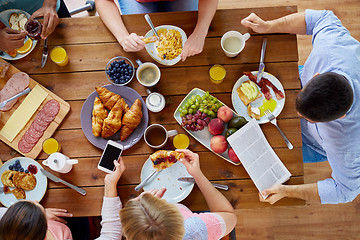 Image showing people with smartphones eating food at table