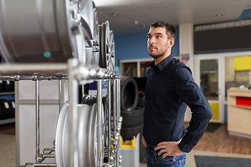 Image showing male customer choosing wheel rims at car service