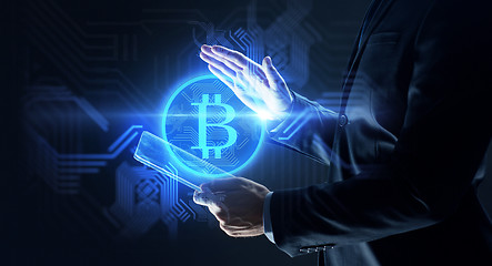 Image showing businessman with tablet pc and bitcoin hologram