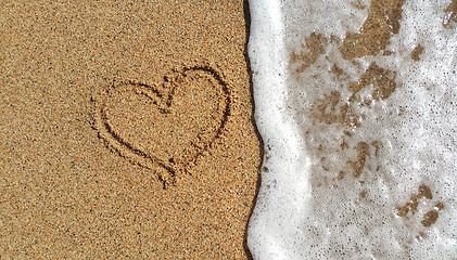 Image showing Heart drawing in the sand and sea foam