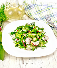 Image showing Salad of radish and sorrel with oil in plate on board