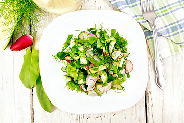 Image showing Salad of radish and sorrel with oil in plate on light board top