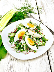 Image showing Salad with radish and egg in plate on wooden table