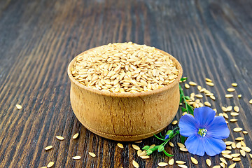 Image showing Flaxen white seed in bowl with flower on board