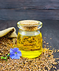 Image showing Oil linenseed with flower and seeds on dark board