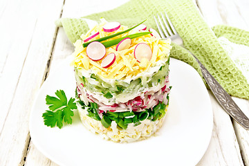 Image showing Salad layered with radish and cucumber in plate on light board