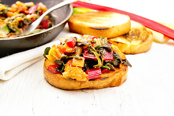 Image showing Bruschetta with stewed chard and orange on board