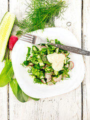 Image showing Salad with radishes and sorrel in plate on board top