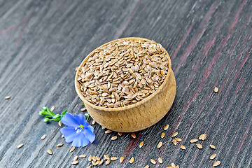 Image showing Flaxen brown seed in bowl with flower on board