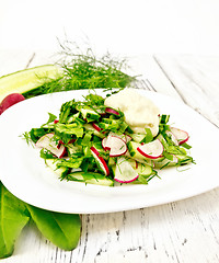 Image showing Salad with radishes and sorrel in plate on wooden table