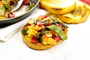 Image showing Bruschetta with stewed chard and orange on light board