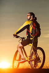 Image showing Man in helmet and glasses stay on the bicycle