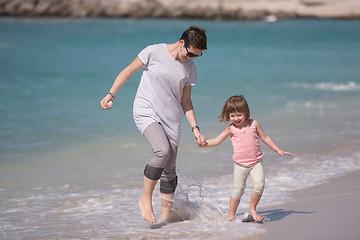 Image showing mother and daughter running on the beach