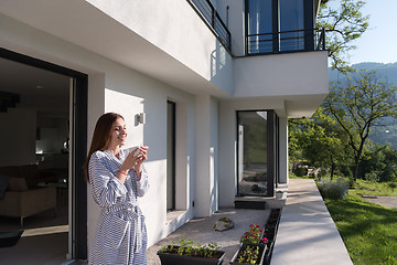 Image showing woman in a bathrobe enjoying morning coffee