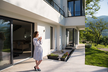 Image showing woman in a bathrobe enjoying morning coffee