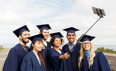 Image showing group of happy students or graduates taking selfie