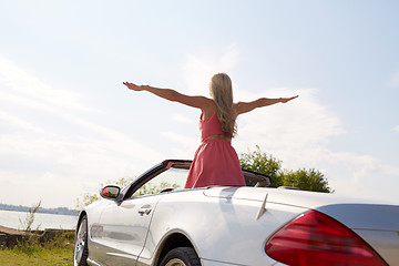 Image showing happy young woman in convertible car at seaside