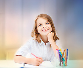 Image showing smiling little student girl drawing at school