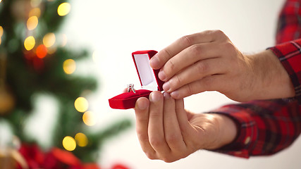 Image showing close up of hands with ring in christmas gift box